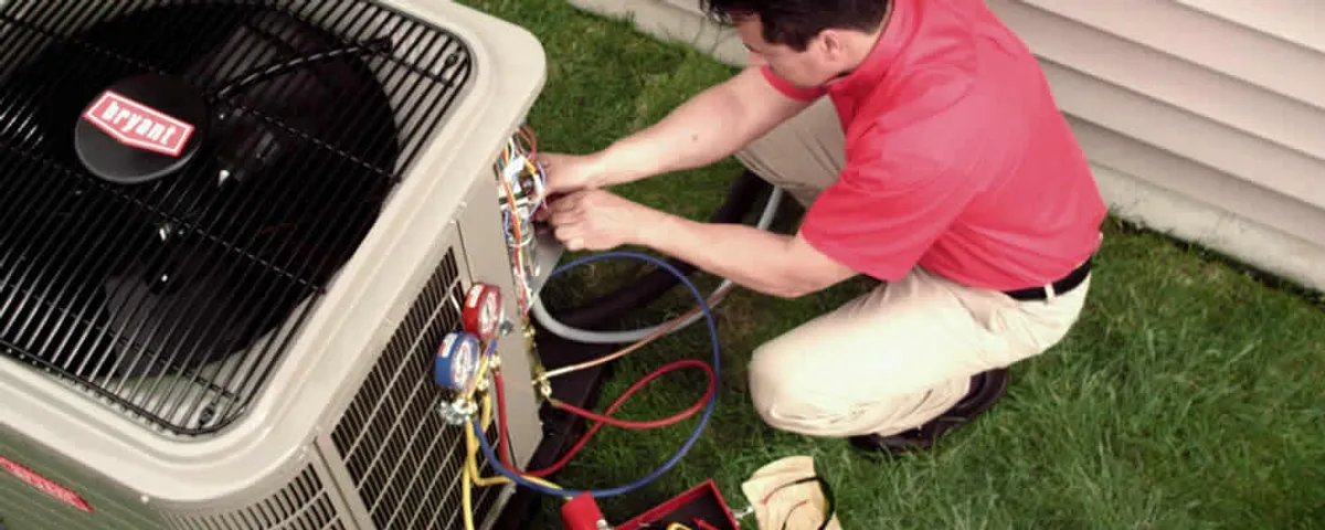 HVAC technician servicing an outdoor air conditioner unit in Newton, MA