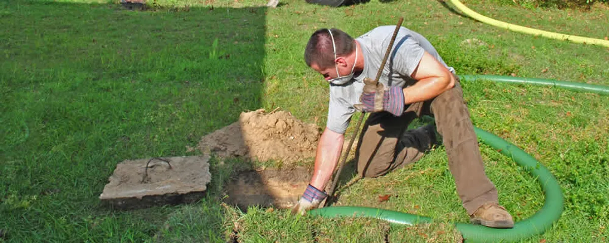 Septic pumping technician servicing a residential septic tank in Newton, MA